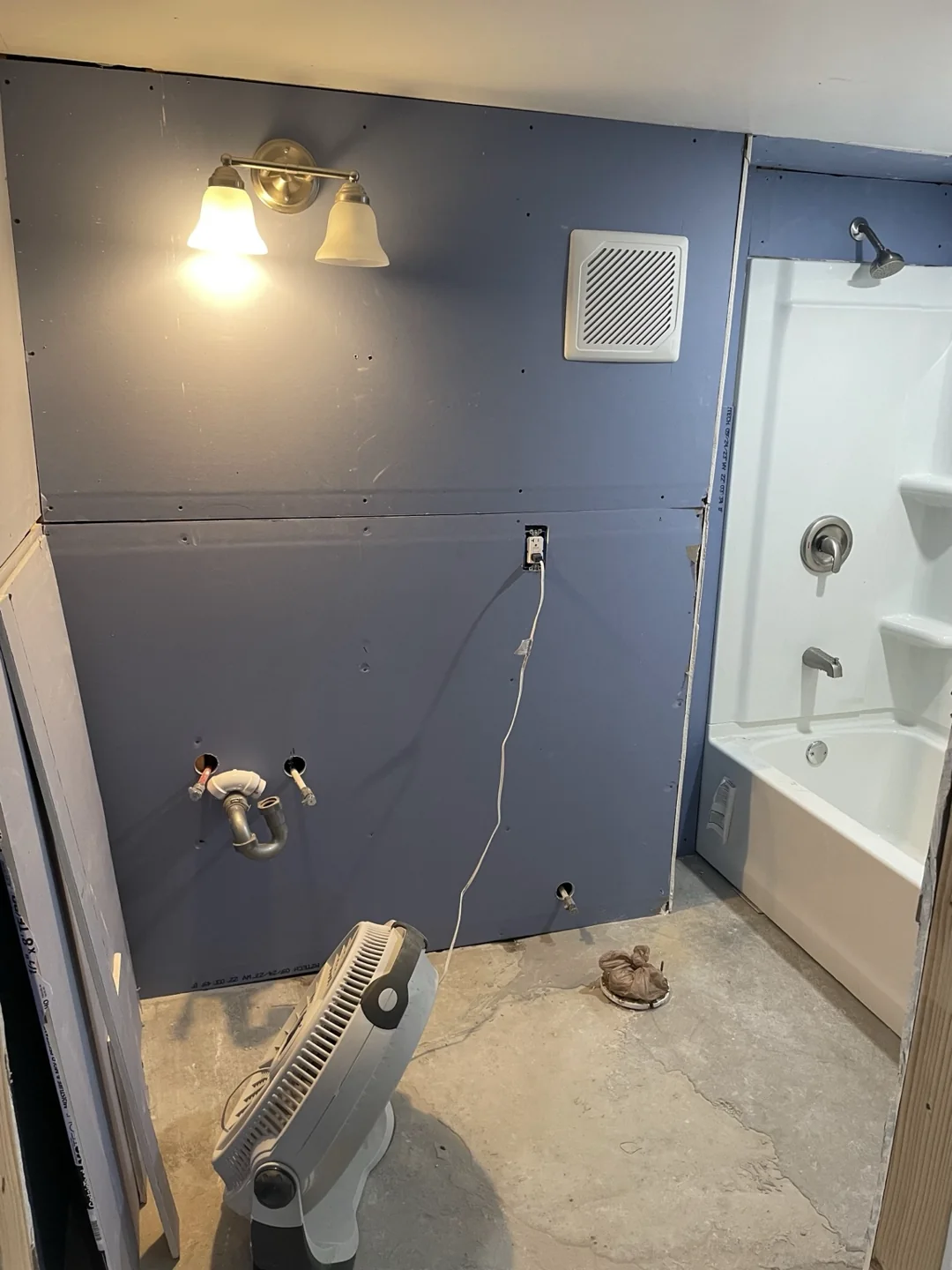 Bathroom wall repair and painting preparation beside the tub and shower surround.