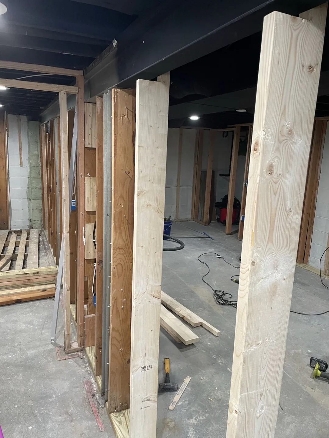 Wood framing for basement partitions and doorways during renovation.