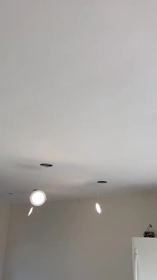 Video still showing a flat ceiling and illuminated LED downlights during installation.