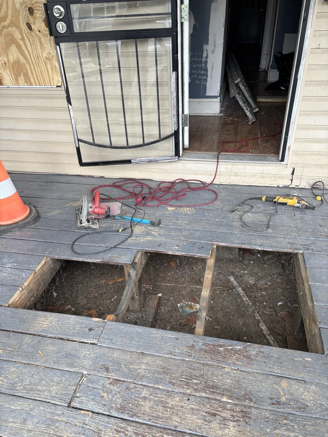 Porch deck boards removed to expose framing during repair work.