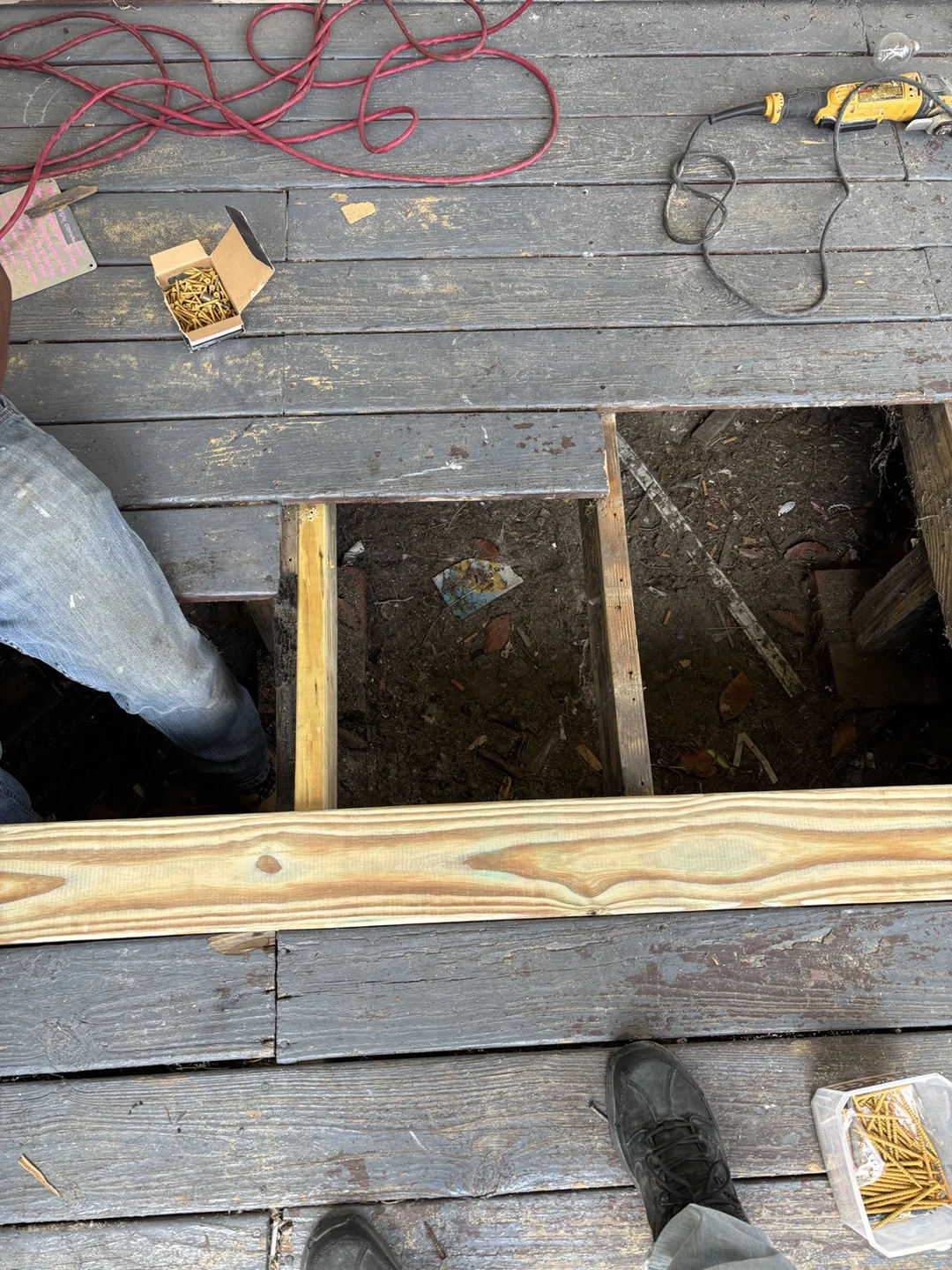 Close-up of the open porch deck and wood framing during repairs.